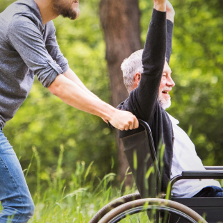 Image of a man in a wheelchair with his hands in the air and smiling