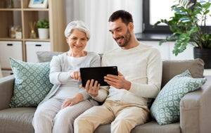  A young man with an older lady using a tablet 